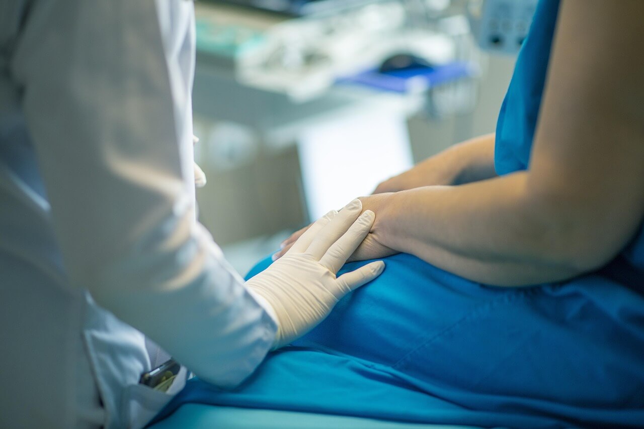 Close up of a medical professional touching a patient's hand