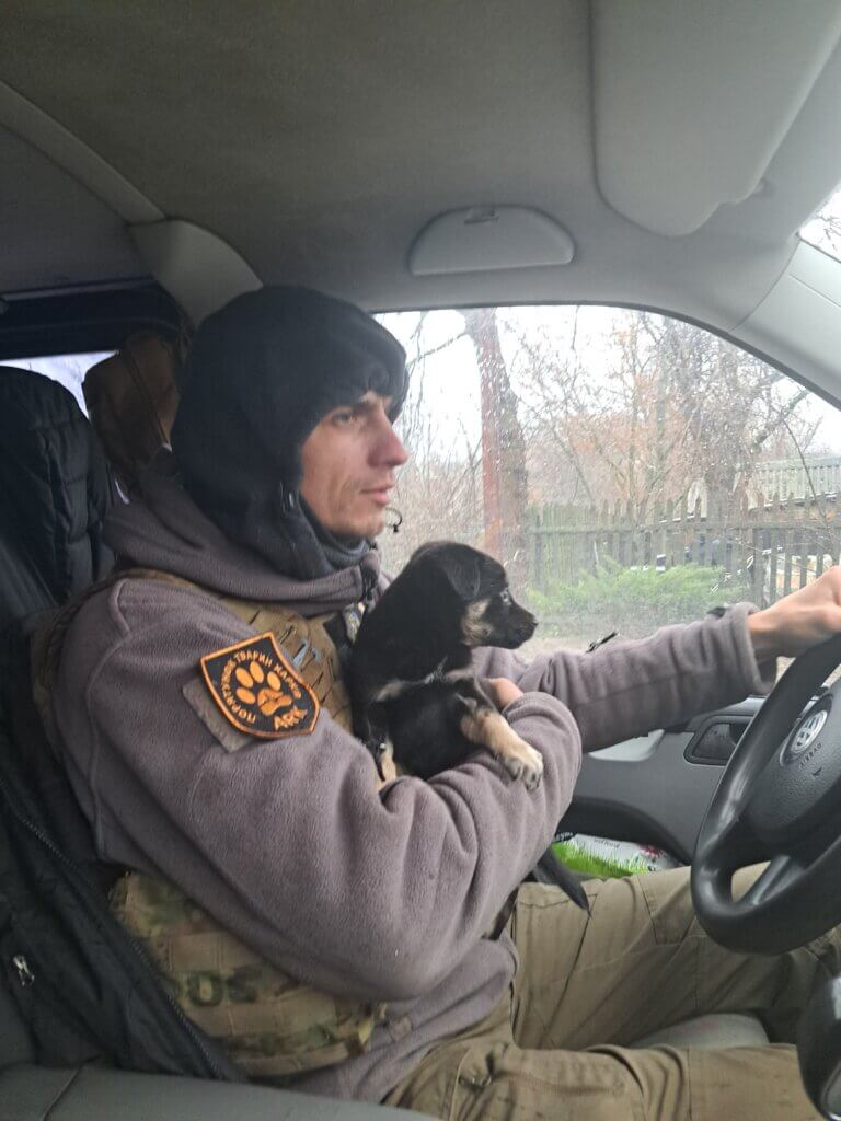 Igor driving while holding a puppy