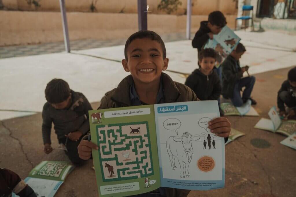 A child holding up an activity book