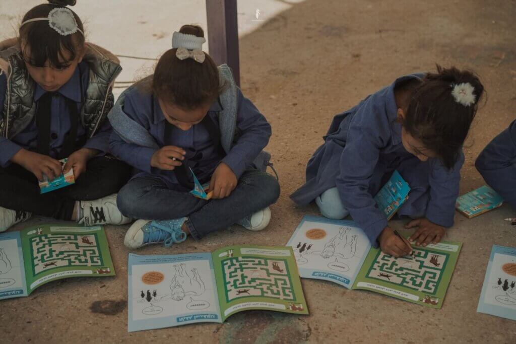 Three children with activity books