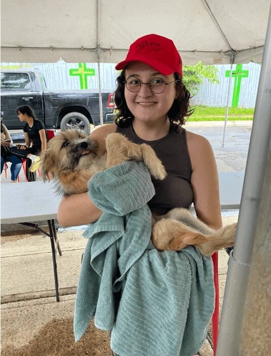 A woman holding her brown companion dog