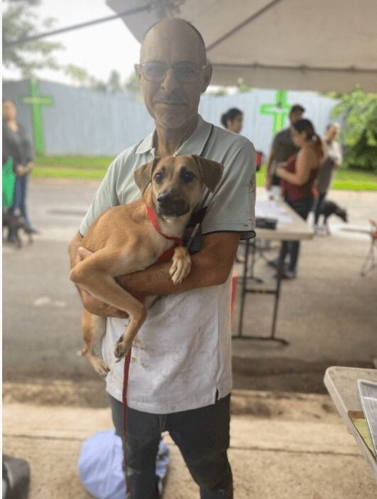 A guardian holding his tan companion dog