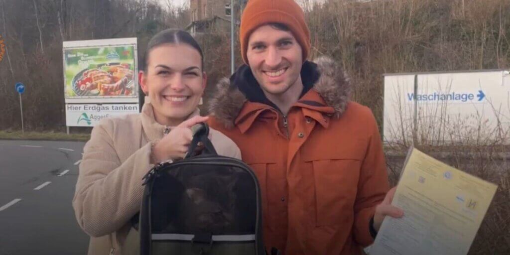 Two people holding a cat carrier