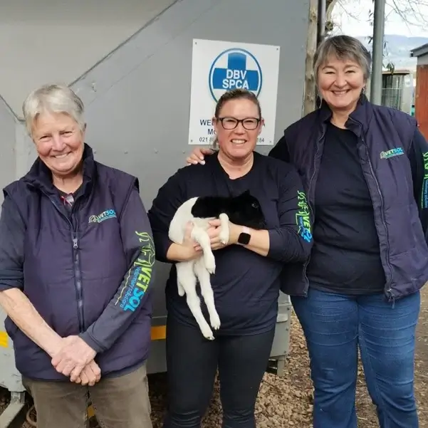 Group photo with a person holding a baby goat