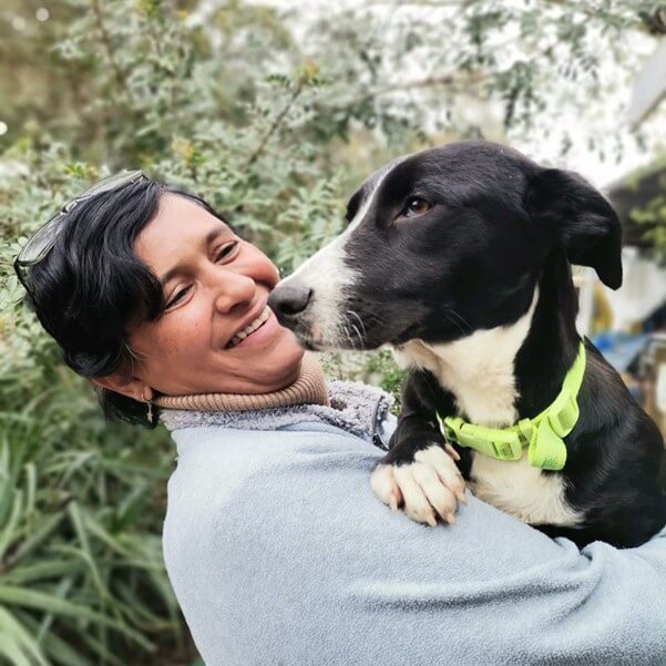 Person holding a black and white dog